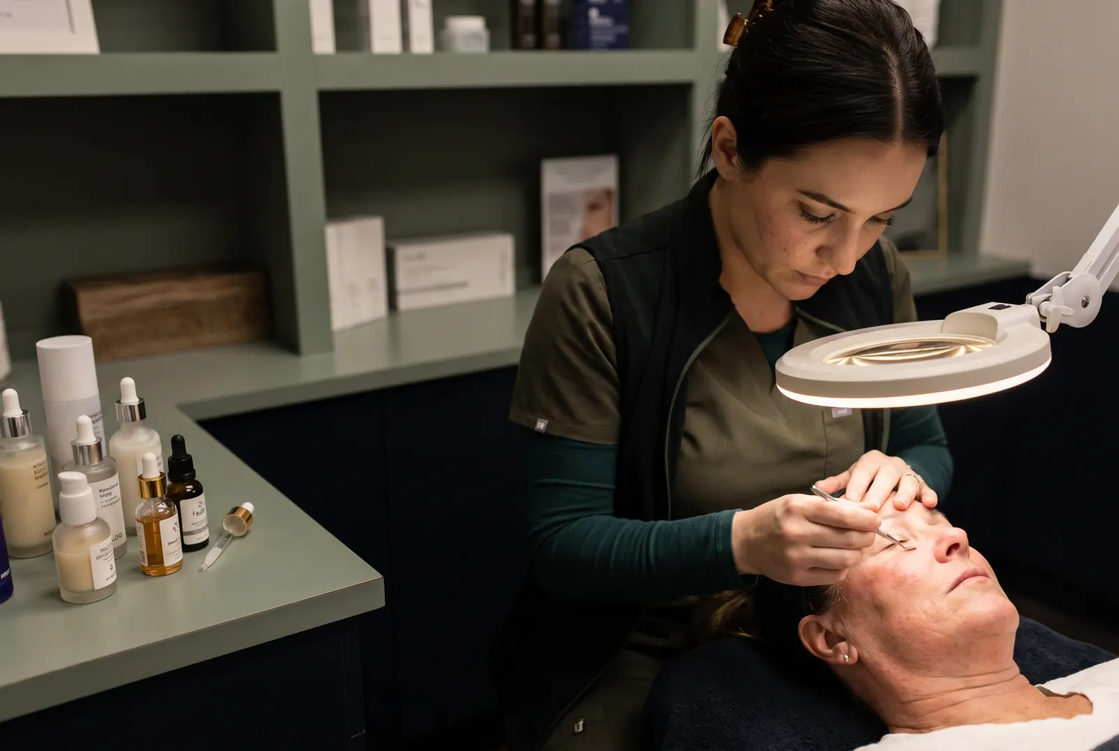 Licensed esthetician examining sun damage before facials Cedar Rapids treatment